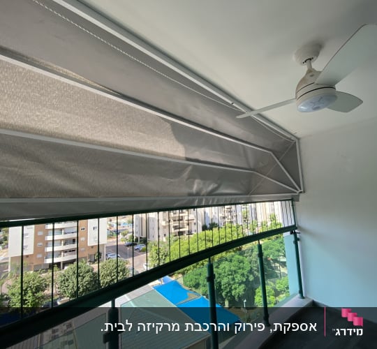 סוכך מרקיזה מתקפל בגוון אפור מותקן במרפסת שמש
